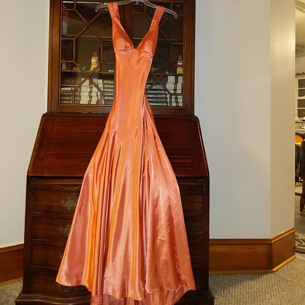 Peach colored, floor length dress.